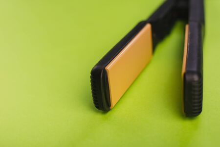 Black Hair Straighteners on a green background.の写真素材