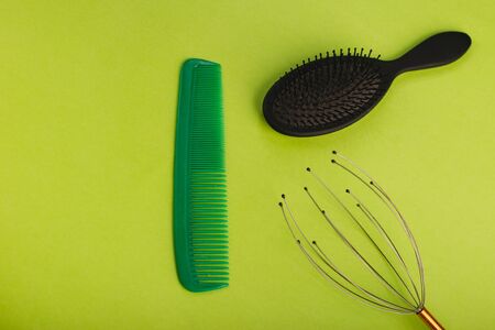 Green and black hairbrush on a green background.の写真素材