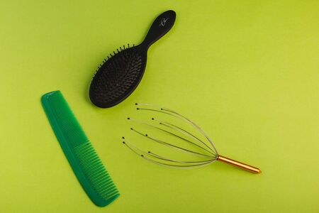 Green and black hairbrush on a green background.の写真素材