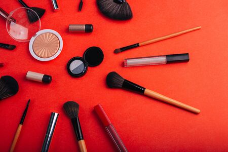 Cosmetics on a bright orange background. Makeup brushes,の写真素材