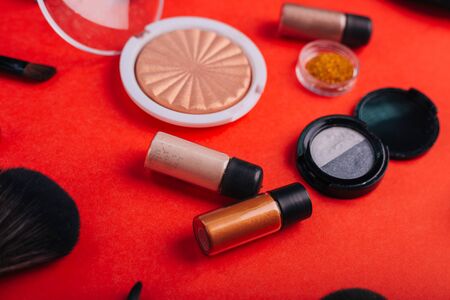 Cosmetics on a bright orange background. Makeup brushesの写真素材