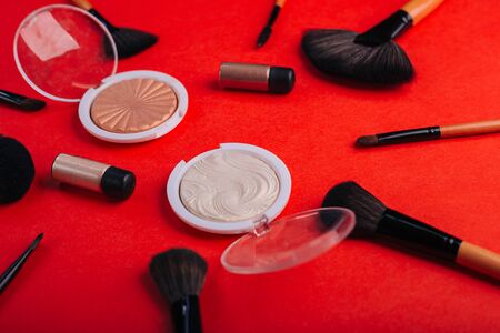 Cosmetics on a bright orange background. Makeup brushesの写真素材