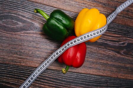 Diet bell pepper multicolored on a dark wooden background. Red, yellow and green peppers are on the table withの写真素材