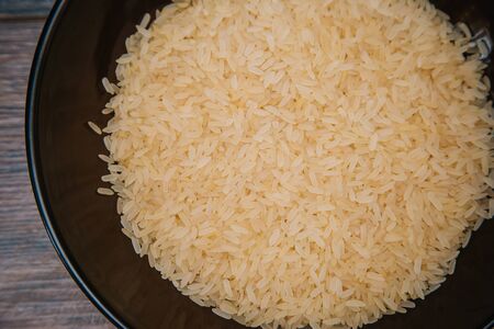 Rice in a dark cup. Ingredients for the dish.の写真素材