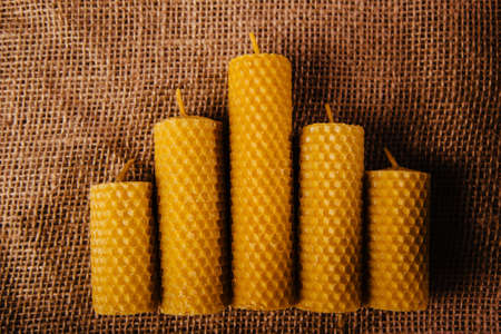 Yellow beeswax candle. A beautiful eco souvenir made from natural products. On sackclothの写真素材