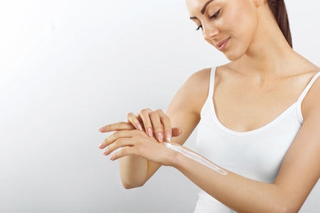 beautiful female hand with white cream isolated on a white backgroundの写真素材