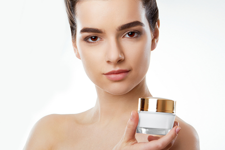 Skincare. Beauty Concept. Young pretty woman holding cosmetic cream. Cosmetology.Beauty and spa.の写真素材