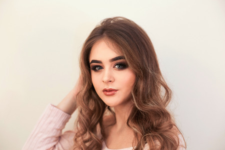 Beautiful model girl with curly hair. Beautiful Young Female with Clean Fresh Skin close up.Skin care face. Cosmetology. Beauty Woman face Portrait.の写真素材
