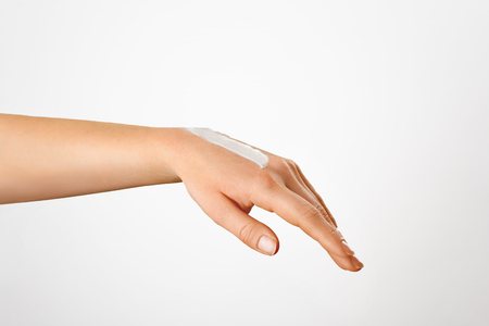 Woman hand with french manicure isolated on white background. Moisturizer. Beautiful Hand with creamの写真素材