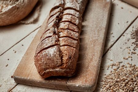 Freshly baked bread .Top view of sliced wholegrain bread on dark rustic wooden  background closeup....