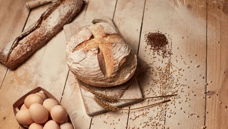 Loaf of bread on wooden background, food closeup. Bread at leaven. Unleavened bread.