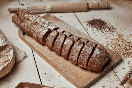 Freshly baked bread .Top view of sliced wholegrain bread on dark rustic wooden  background closeup....