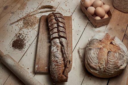 Freshly baked bread .Top view of sliced wholegrain bread on dark rustic wooden  background closeup....