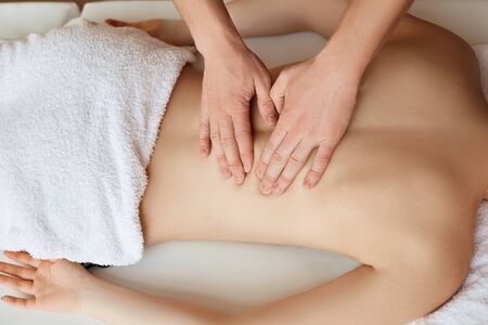 Young woman relaxing with hand massage at beauty spa.
