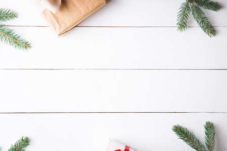 Beautiful Christmas composition on wooden white background with Christmas gift boxes, snowy fir...