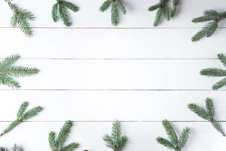 Beautiful Christmas composition on wooden white background with Christmas gift boxes, snowy fir branches, conifer cones, cinnamon dried fruits, holiday decoration, caramel stick. New Year. Top view, copy space.の写真素材