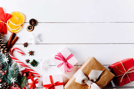 Beautiful Christmas composition on white background with golden Christmas gift boxes, snowy fir branches, conifer cones, holiday decoration. Top viewの写真素材