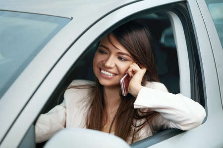 Beautiful elegant woman talking on the phone while traveling by car. Business Woman