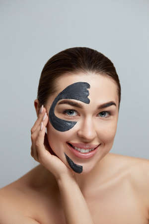 Beauty Woman Face Mask. Portrait Of Beautiful Girl With Cosmetic Black Peeling Mask On Facial Skin Moisturizer Mask. Skin Care. Cosmetologyの写真素材
