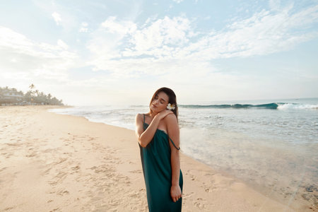 Portrait of beautiful young woman in dress on the beach. Pretty girl on tropical beach. Freedom concept, holiday, beach, sky background.の写真素材