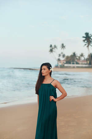 Portrait of beautiful young woman in dress on the beach. Pretty girl on tropical beach. Freedom concept, holiday, beach, sky background.の写真素材