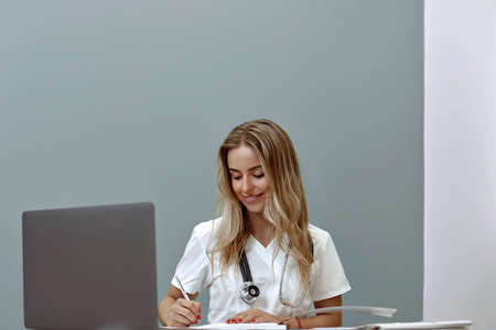 Female doctor working with her laptop in medical officeの写真素材