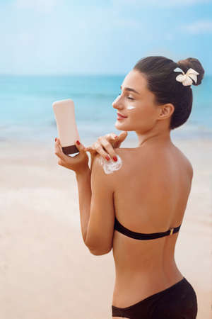 body sun protection. sunscreen. Woman smile applying sun cream on shoulder. skincare.の写真素材