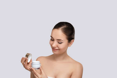 skincare. beauty concept. Young woman holding cosmetic moisturizing cream. Dermatology.の写真素材