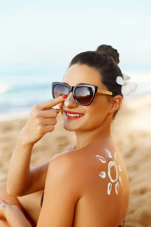 Suntan Lotion. Sexy Young Woman in Bikini Applying Sunscreen Solar Cream.Sun Protection. sun cream....