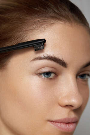 Eyebrow Care. Young Female Model Shaping Brown Eyebrows.の写真素材