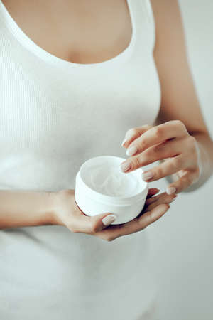 Beautiful Woman Hands. Female Hands Applying Cream, Lotion. Spa and manicure concept. Female hands with french manicure. Soft skin, skincare concept. Hand Skin Care.の写真素材