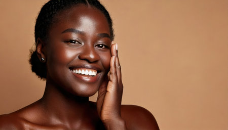 A joyful woman smiles brightly while gently touching her face against a warm beige backdrop in a calm indoor setting, highlighting her natural beauty.の素材