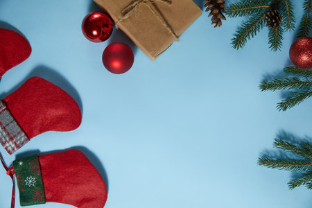 Beautiful Christmas composition on blue background. Christmas present boxes, socks, fir spruce branches, conifer cones, caramel stick, gift. New Year. Top view, copy space.の写真素材