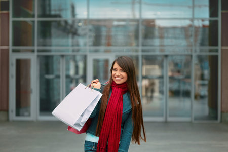 Beautiful Happy Woman Holding Shopping Bags And Smiling Near The Mallの写真素材