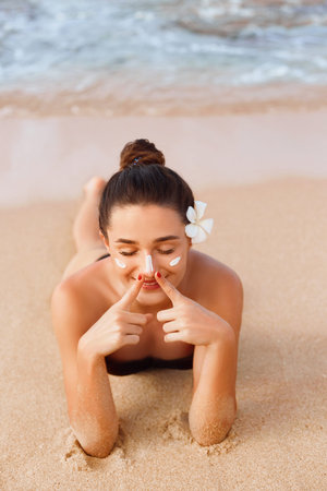 Young Woman in Bikini Holding Bottles of Sunscreen in Her Hands. Skincare. A Female Applying Sun...
