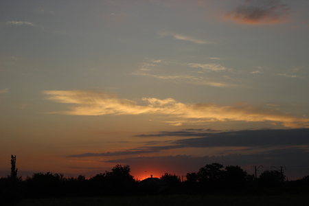 Rural house against the setting sun.の写真素材