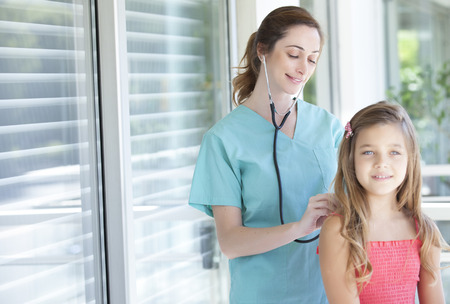 Female doctor with a young little girl patientの写真素材