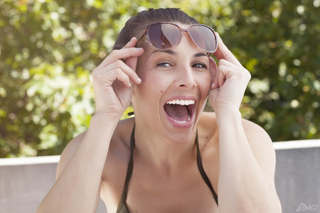Cute latina girl wearing a dark swimsuit in summer enjoying sunの写真素材