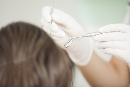 Closeup of dentist examining young woman's teethの写真素材