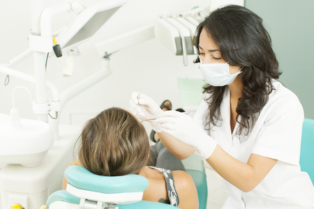 Closeup of dentist examining young woman's teethの写真素材
