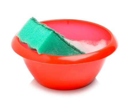 Red bowl and green sponge with foam isolated on whiteの写真素材