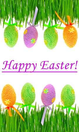 Fresh green grass and colored easter eggs isolated on white