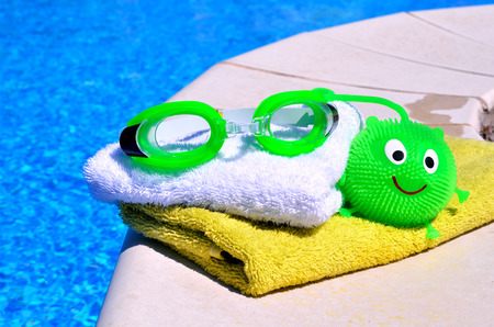 bath towels, goggles, toy against blue wateの写真素材