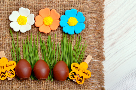 Easter decoration chocolate eggs on the burlap background.