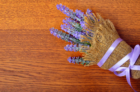 Bouquet of lavender in sack on wooden background.の写真素材