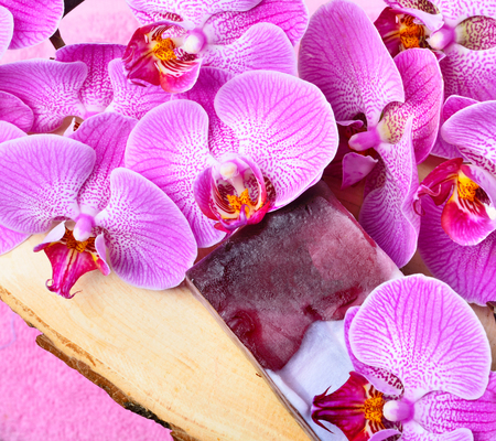 Orchid flowers and handmade soap on wooden background.の写真素材