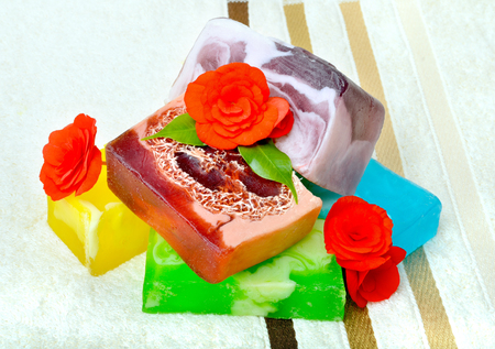 Handmade soap with flowers on a background colored towels.の写真素材