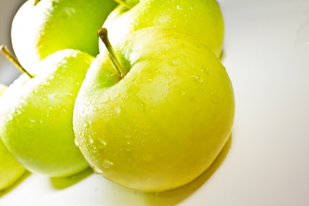 Green apples with water isolated on whiteの写真素材