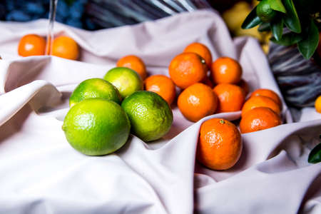 Tangerines and limes on a white drapery.の写真素材