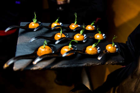 Expensive buffet with gourmet food. Black plate. Catering.